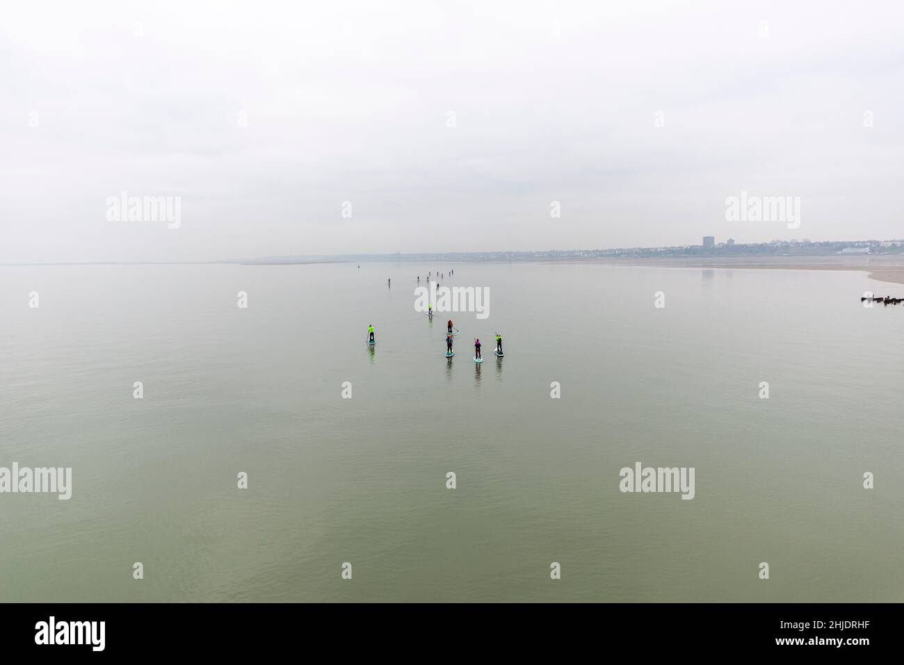Paddle boarding group out on the Thames Estuary early morning returning towards Chalkwell after passing Southend Pier. Flat calm. Wide expanse Stock Photo