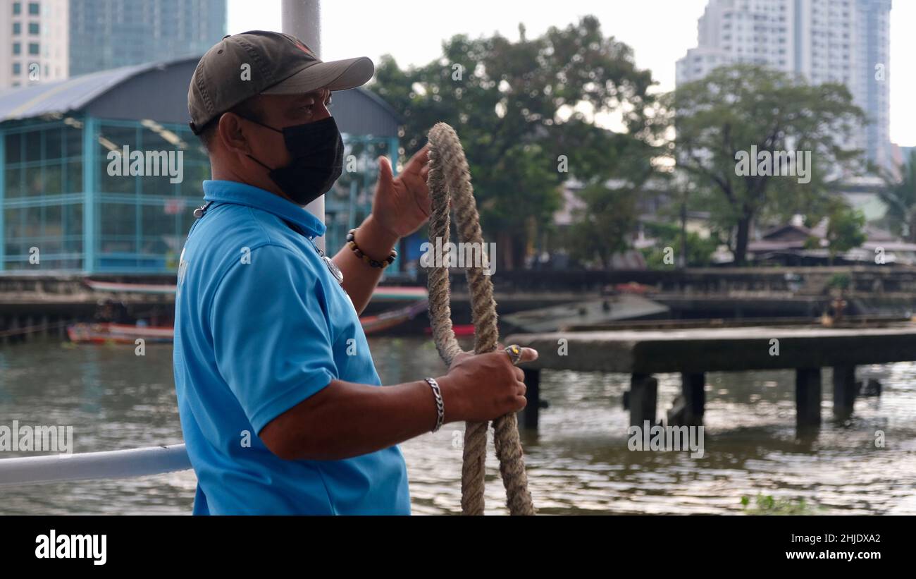 Orange Flag Express Boat Worker lassoing, tethering, tying and docking