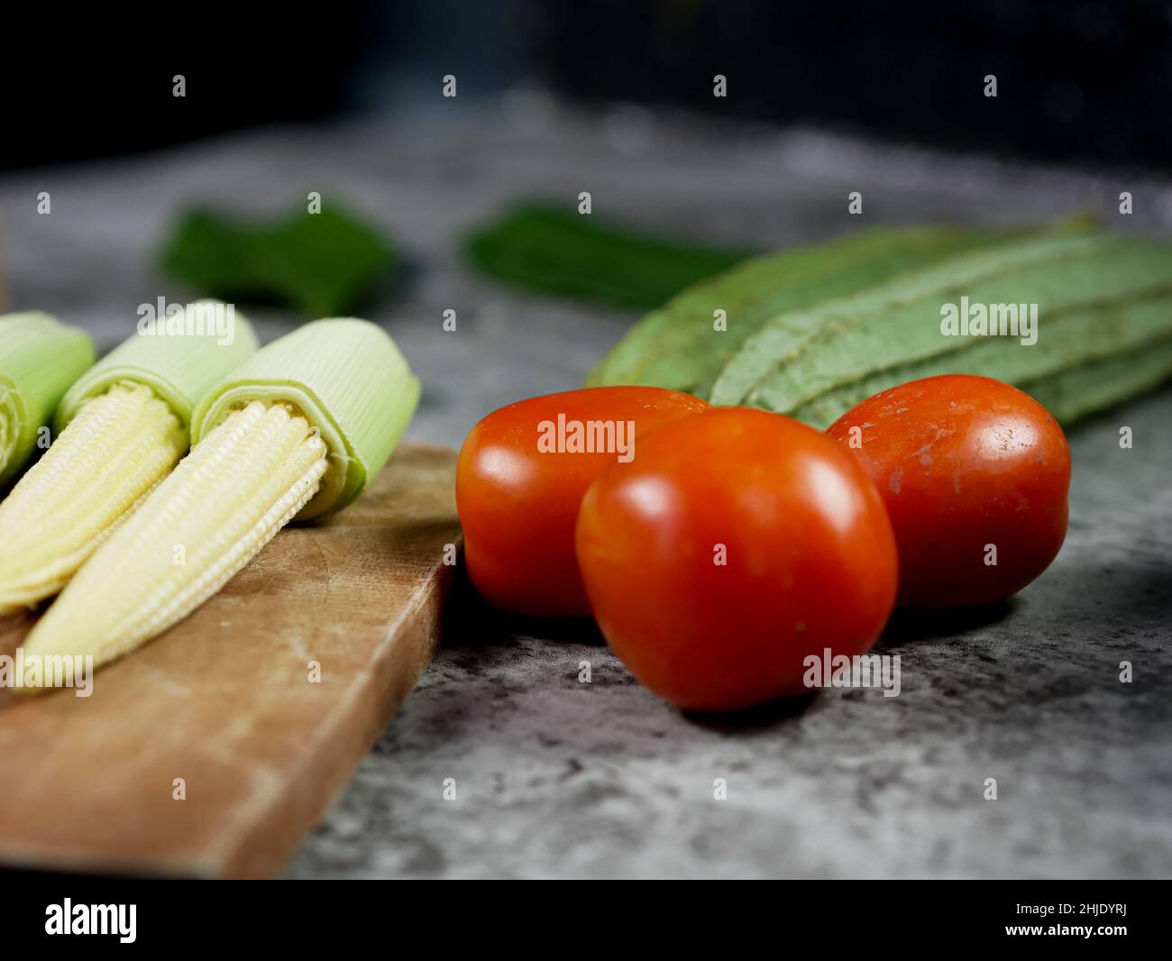 tomatoes on and vegetables on the table. Stock Photo