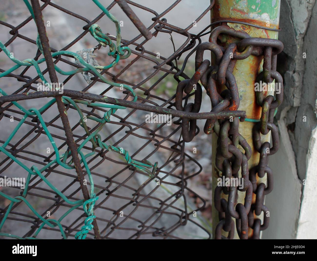 rivate property sign hangs on a metal fence. Gate is locked close with a chain and several padlocks. Stock Photo
