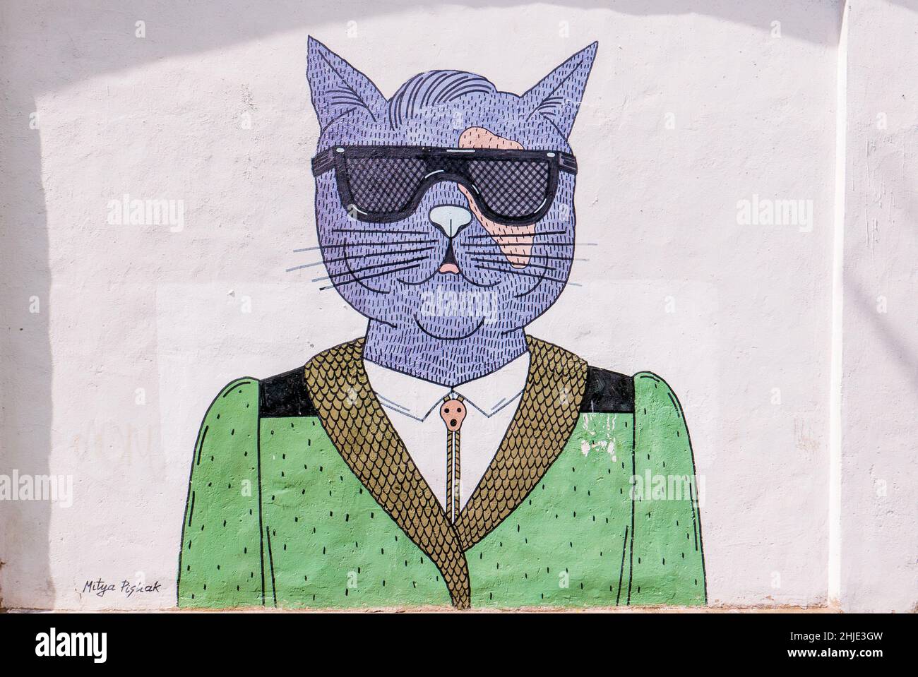 PURPLE by Mitya Pisliak. A purple cat in sunglasses and a green jacket. Street art. Mural in Minsk (Belarus). Dolgobrodskaja st.12. 2016 year Stock Photo