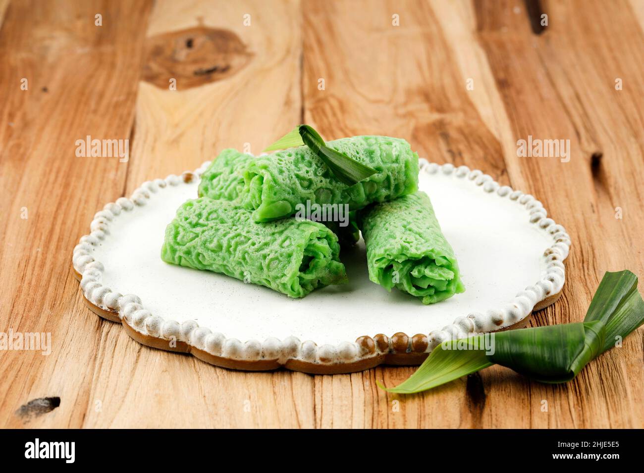 Dadar Gulung or Sweet Coconut Pancake, Indonesian Snack Dessert made from Flour with Sweetened Grated Coconut. Green COlor from Pandan and Suji Leaves Stock Photo