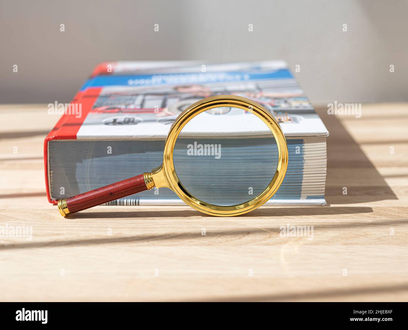 Open technical book for study physics with magnifying glass and ruler