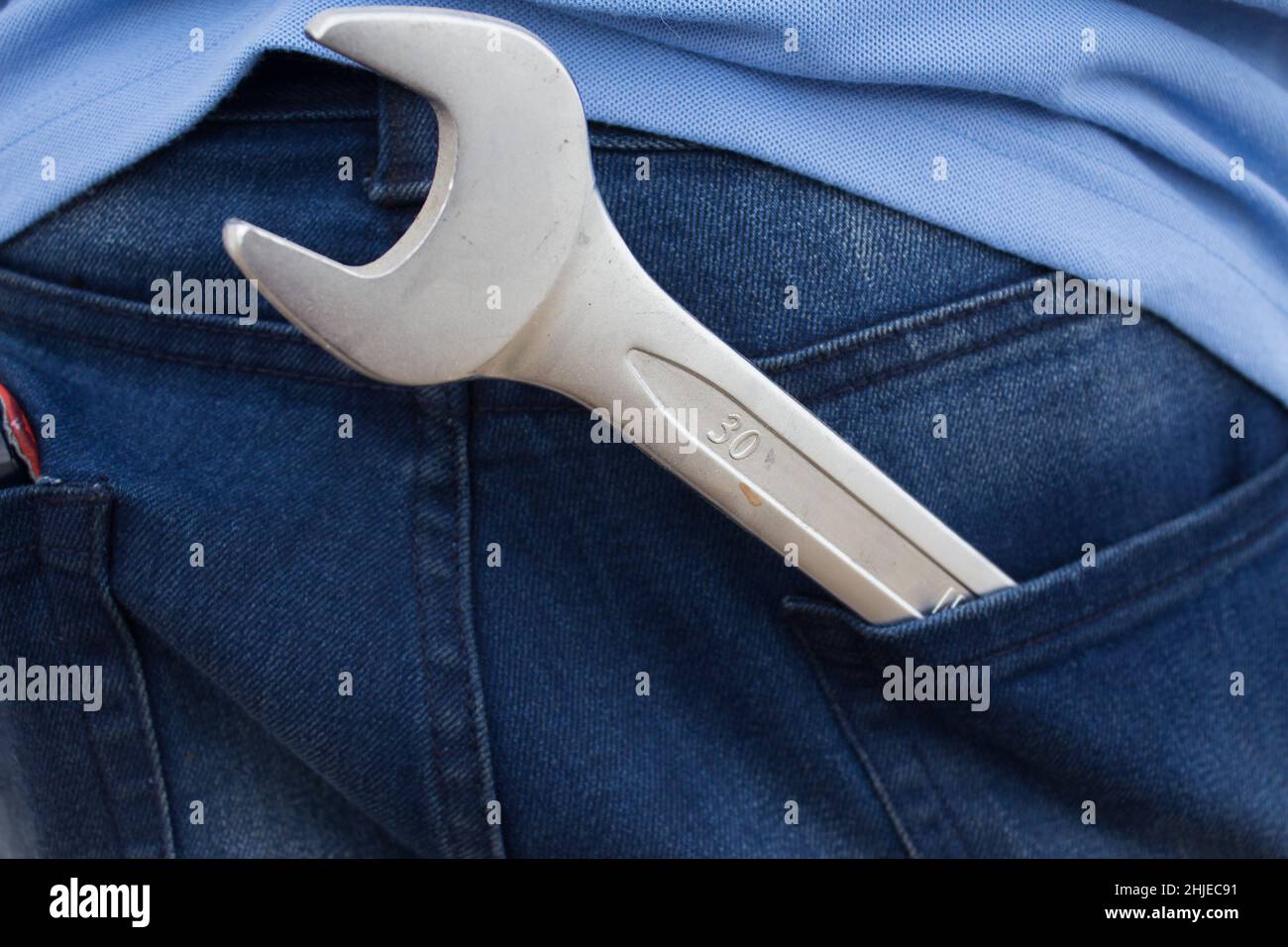 Wrench in the back pocket of jeans. Large and small wrenches as a father and son symbol. Fathers day background with dad- wrench and son - wrench. Hap Stock Photo