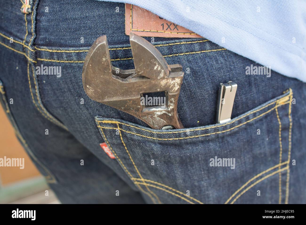 Wrench in the back pocket of jeans. Large and small wrenches as a father and son symbol. Fathers day background with dad- wrench and son - wrench. Hap Stock Photo