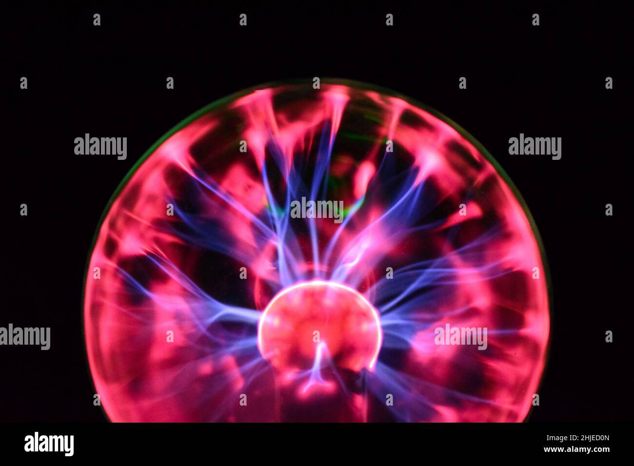 Plasma ball with iridescent lightning in different colors on a very dark background Stock Photo