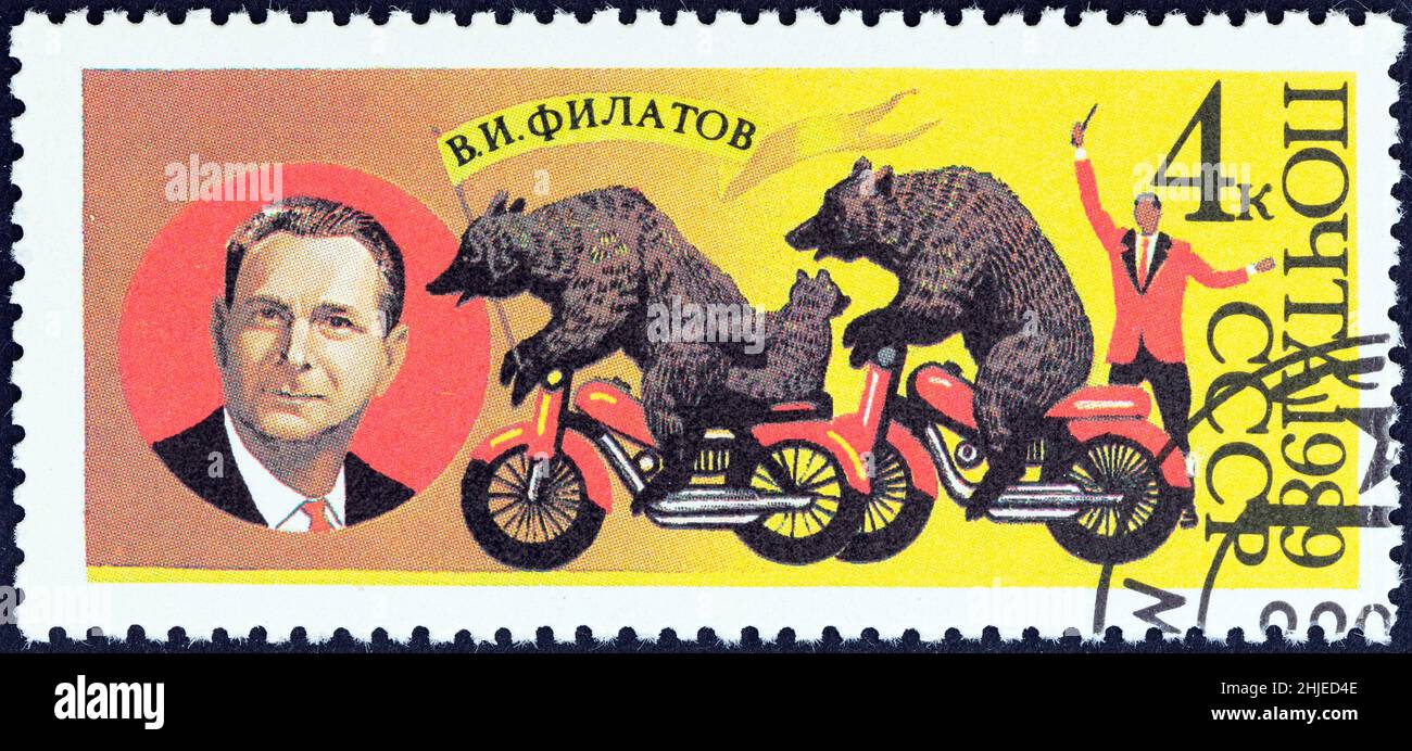 USSR - CIRCA 1989: A stamp printed in USSR shows V. I. Filatov (founder of Bear Circus) and bears on motor cycles, circa 1989. Stock Photo