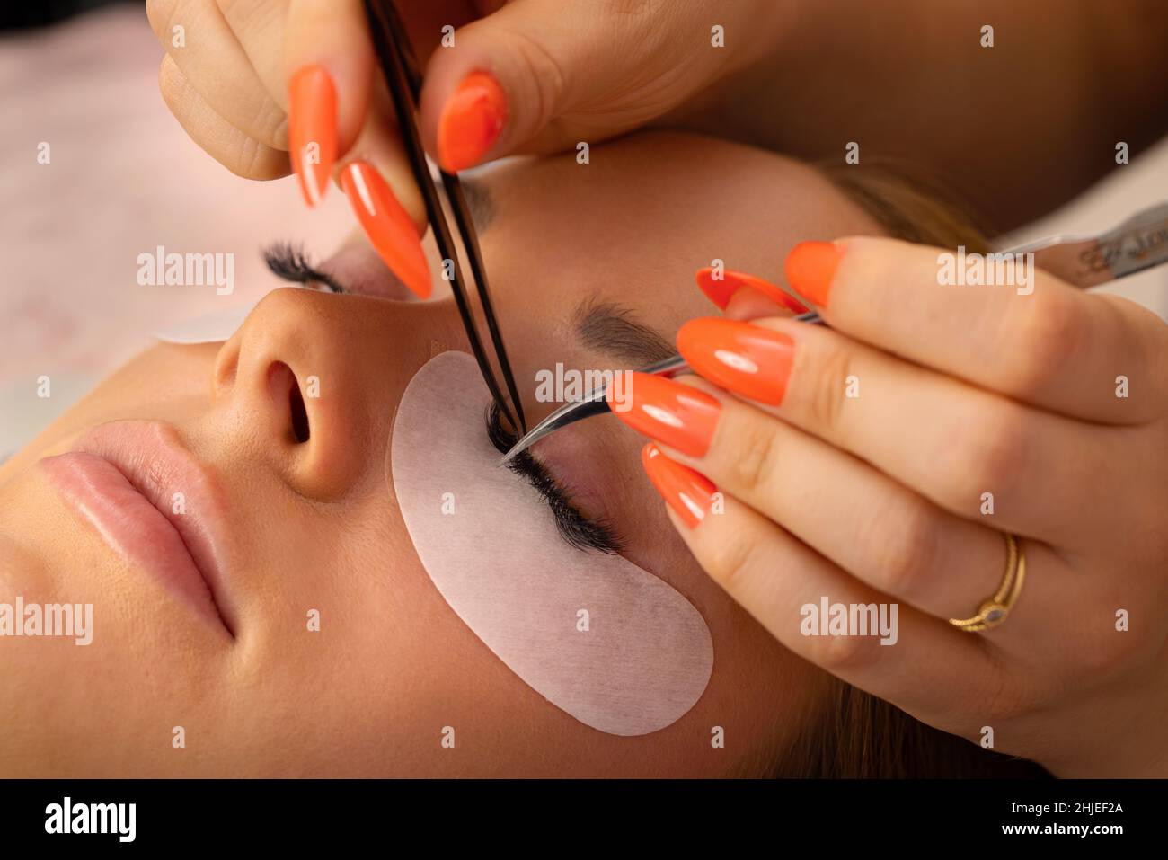 Hands Of Beautician Using Tweezers For Applying False Eyelashes Stock Photo