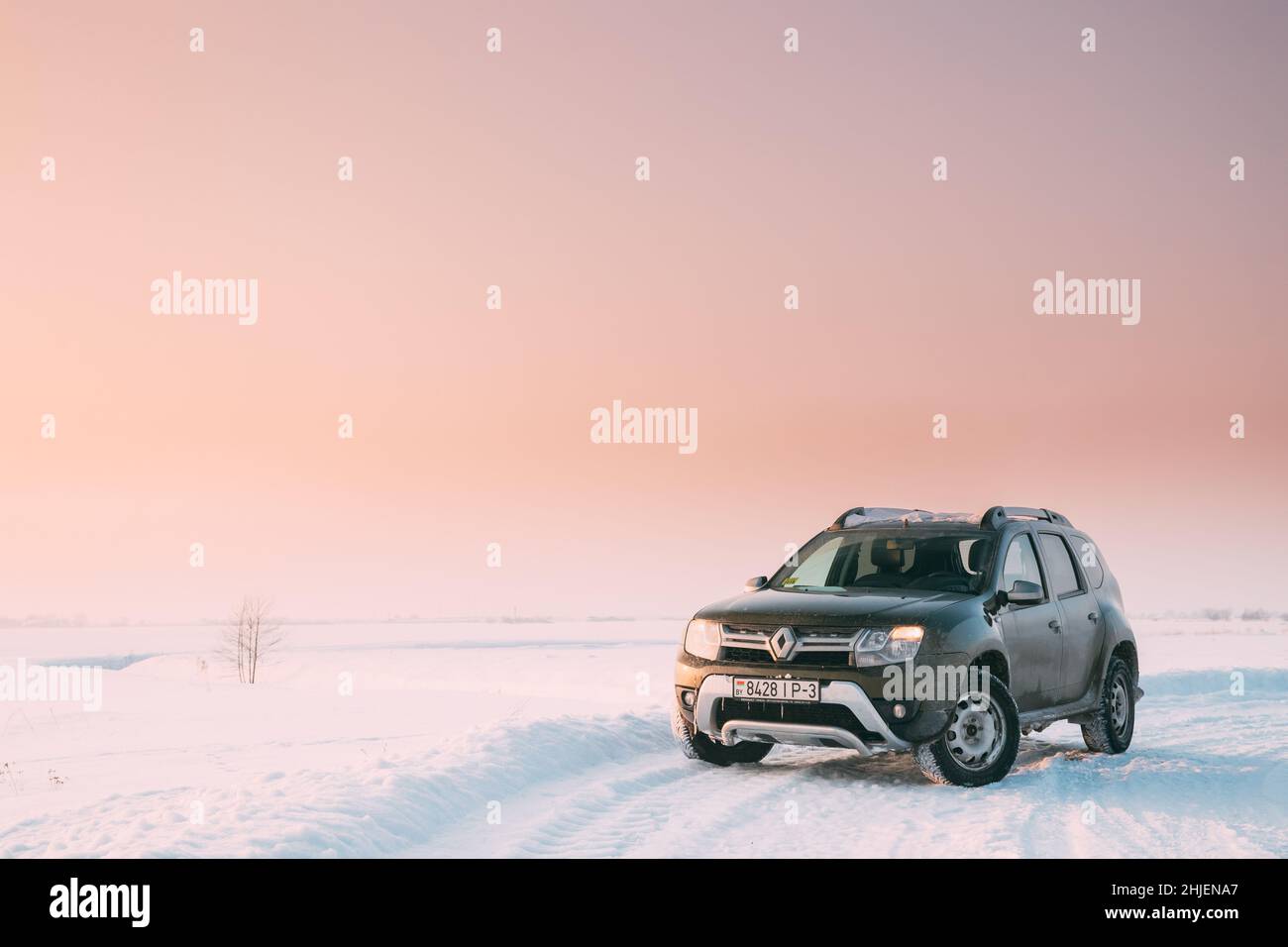 Gomel, Belarus. Car Renault Duster Or Dacia Duster Suv Parked On Winter Snowy Field At Sunset Dawn Sunrise. Stock Photo