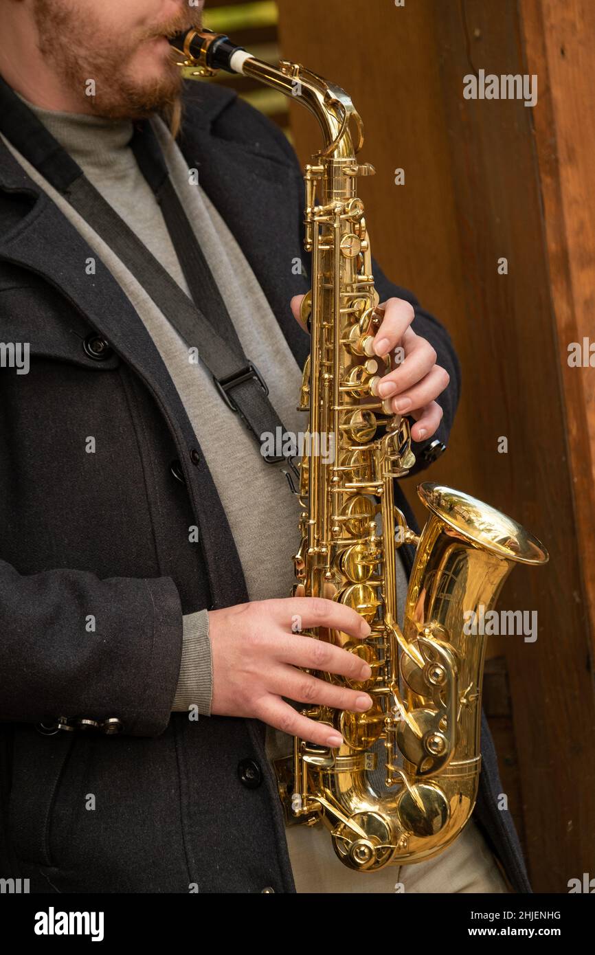 Crop man playing saxophone on street Stock Photo