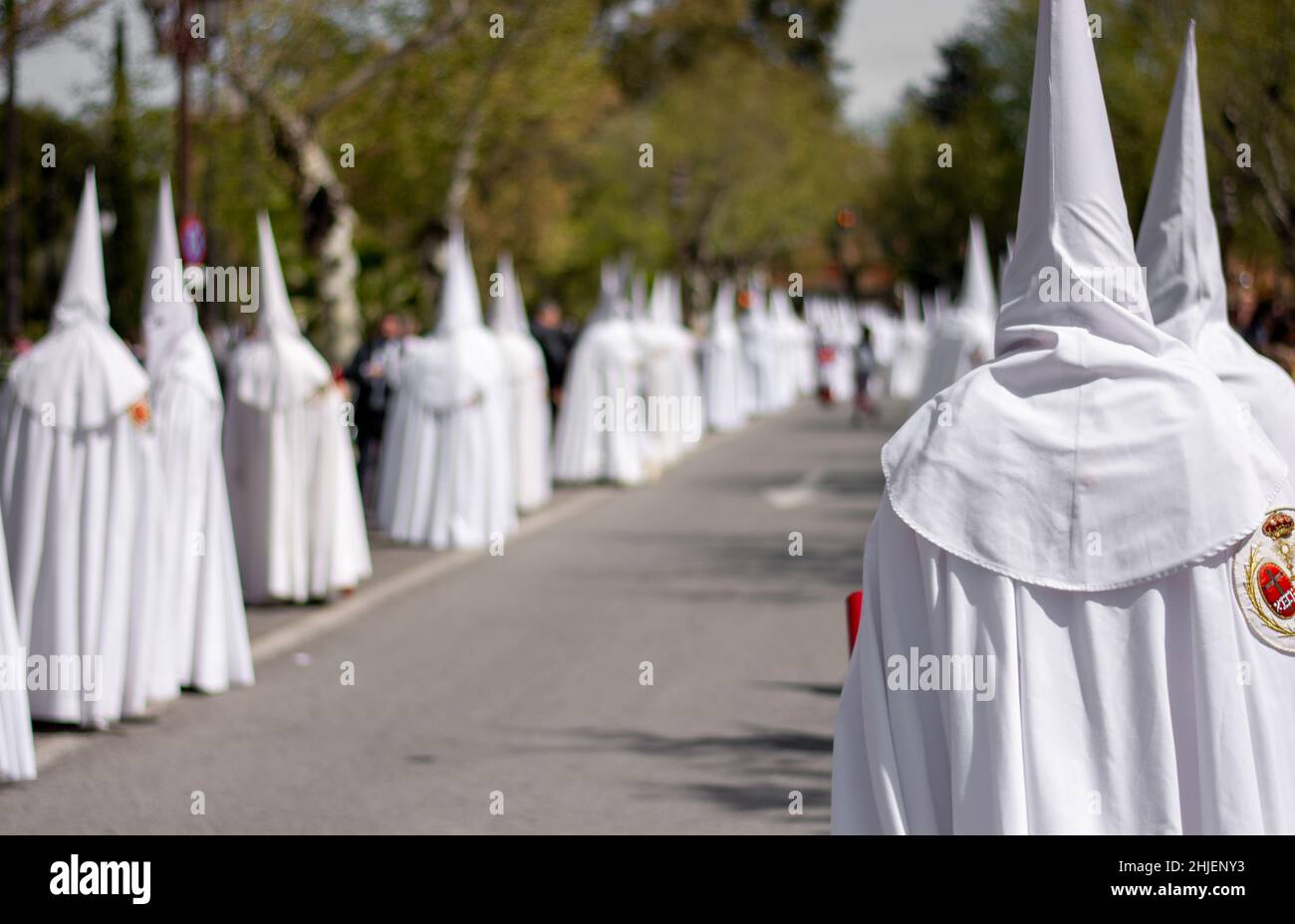 the daughters of hooded penitents accompany Jesus Christ to Mount Calvary Stock Photo