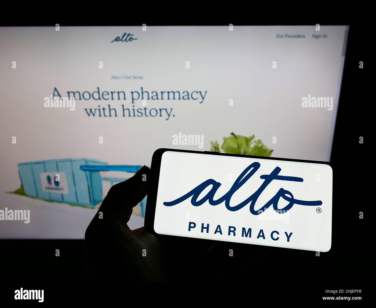 Person holding smartphone with logo of US telehealth company Alto Pharmacy LLC on screen in