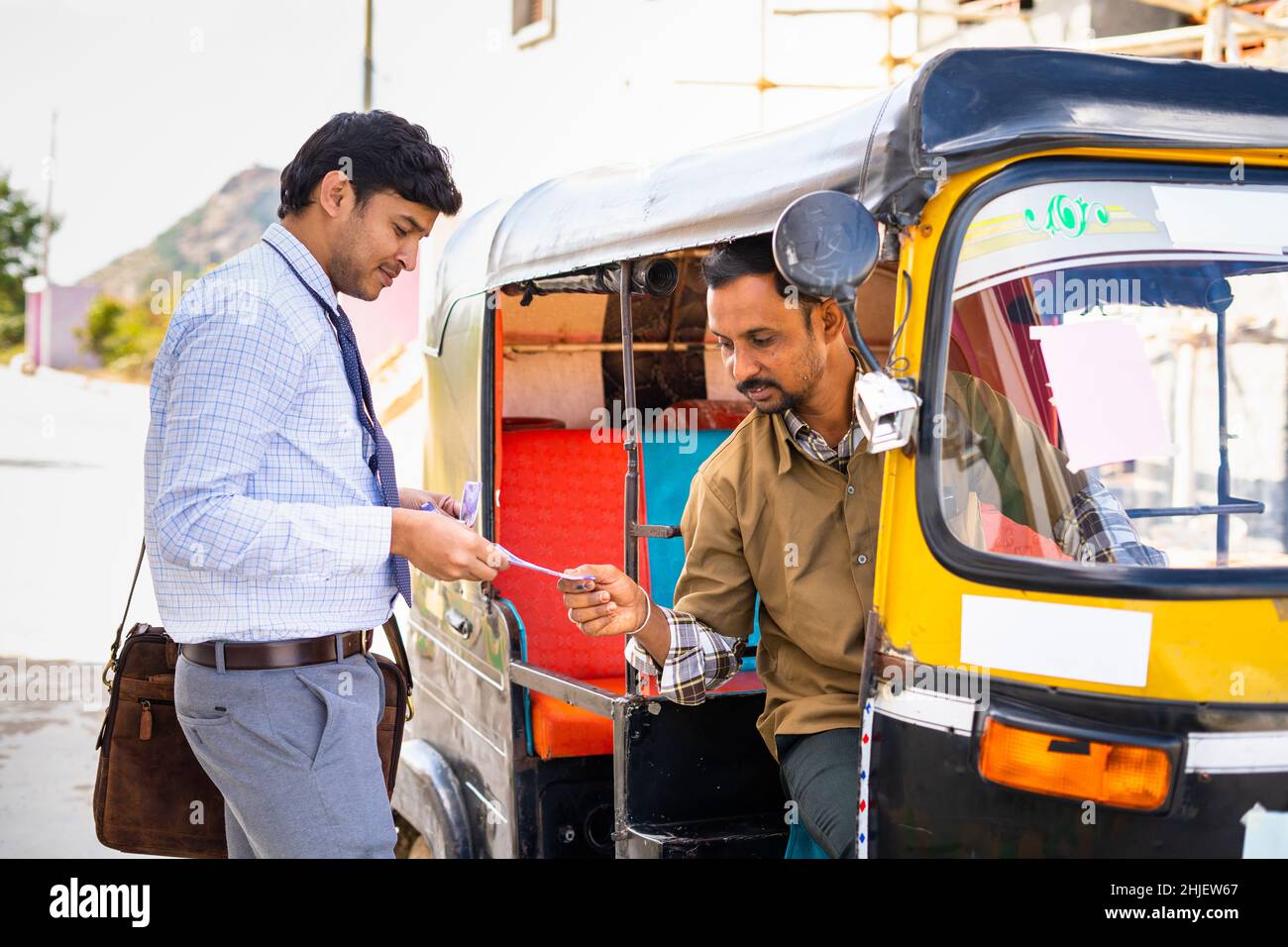 Passenger paying money to auto rickshaw driver after ride - concept of earnings, transportation and commutation Stock Photo