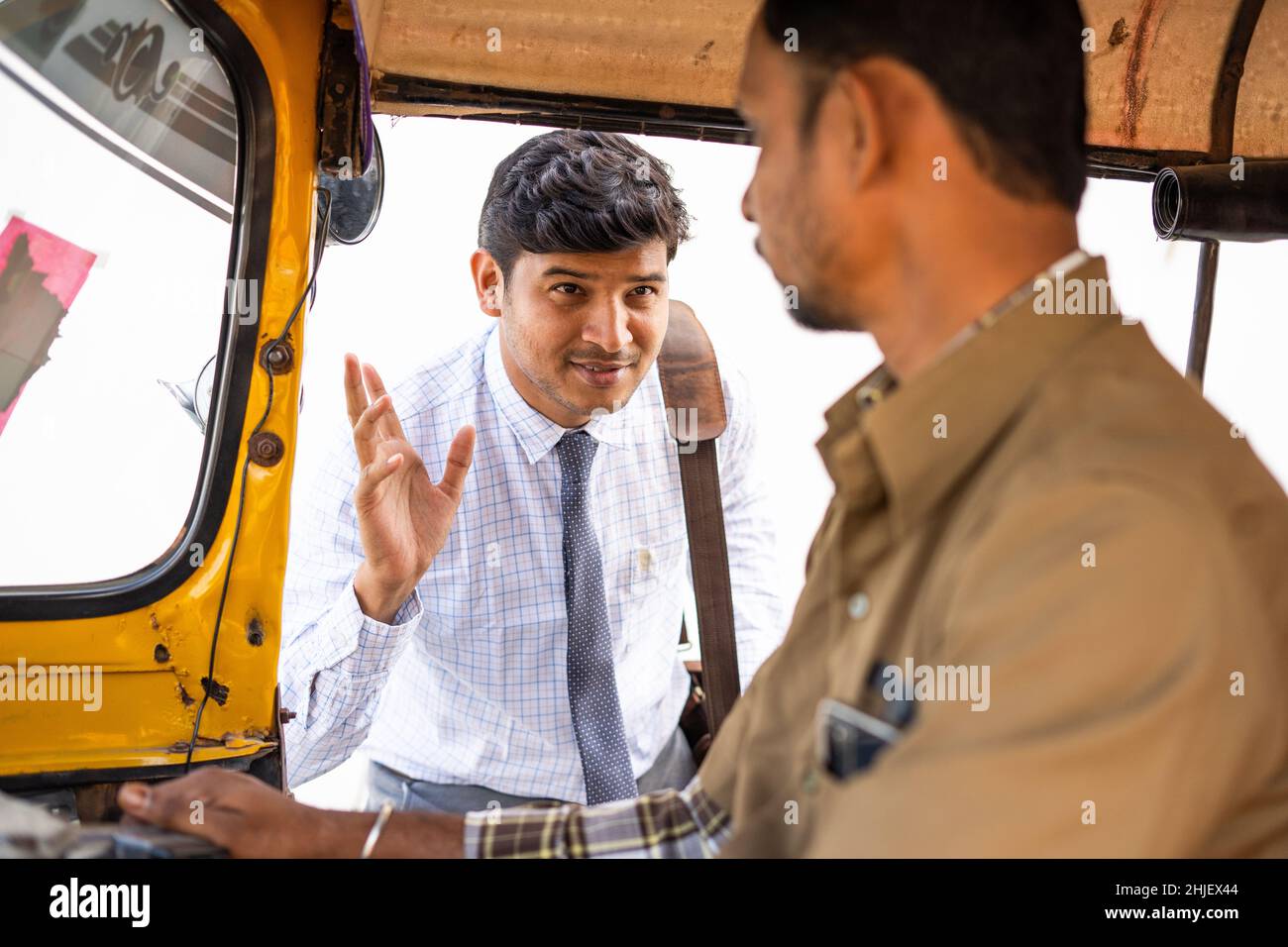 Rack focus shot, passanger negotiation for ride or travel with auto rickshaw driver - concept of transportation, communication and commutation service Stock Photo
