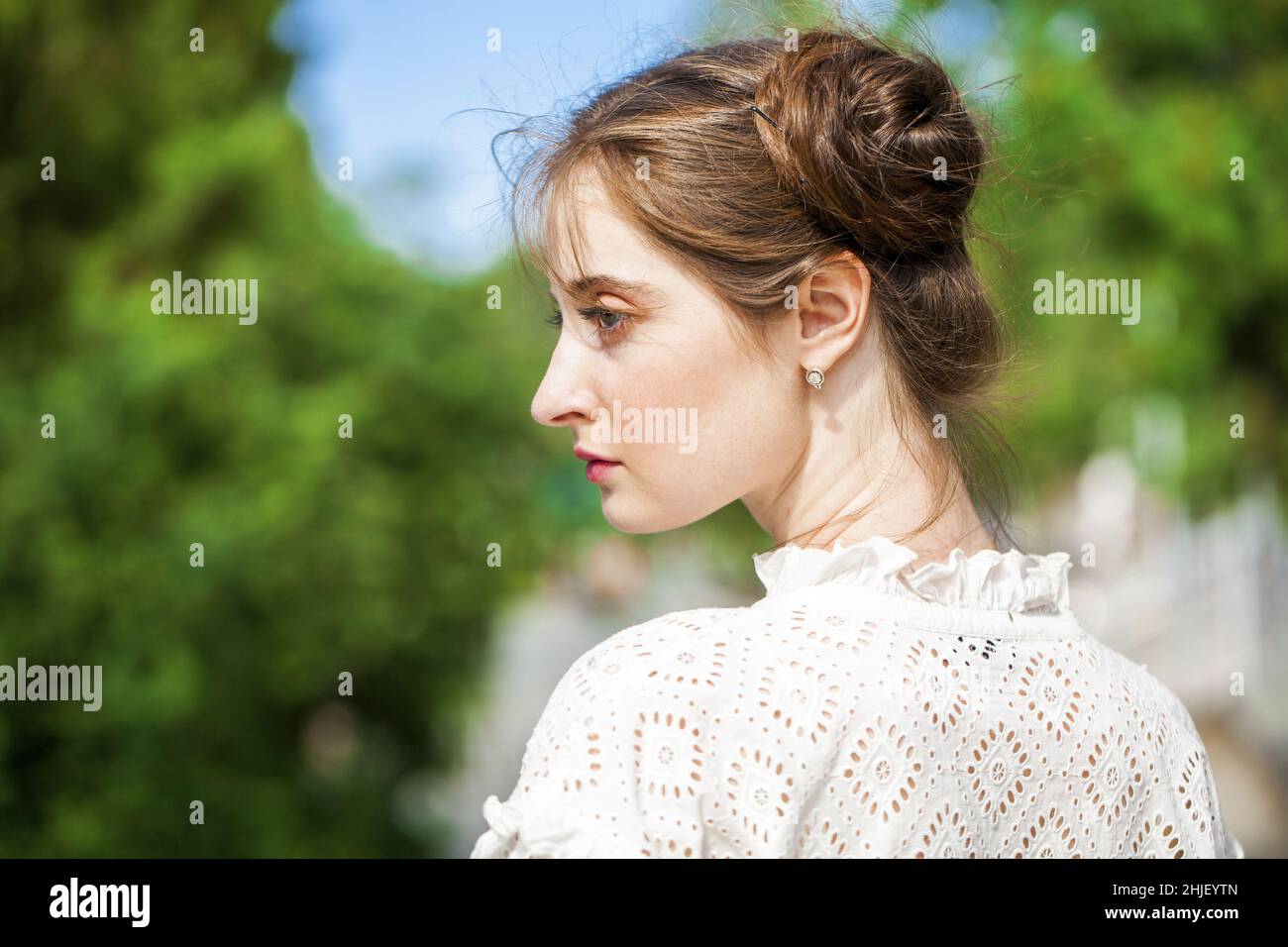 Portrait of a Young beautiful brunette girl in white dress, summer park ...