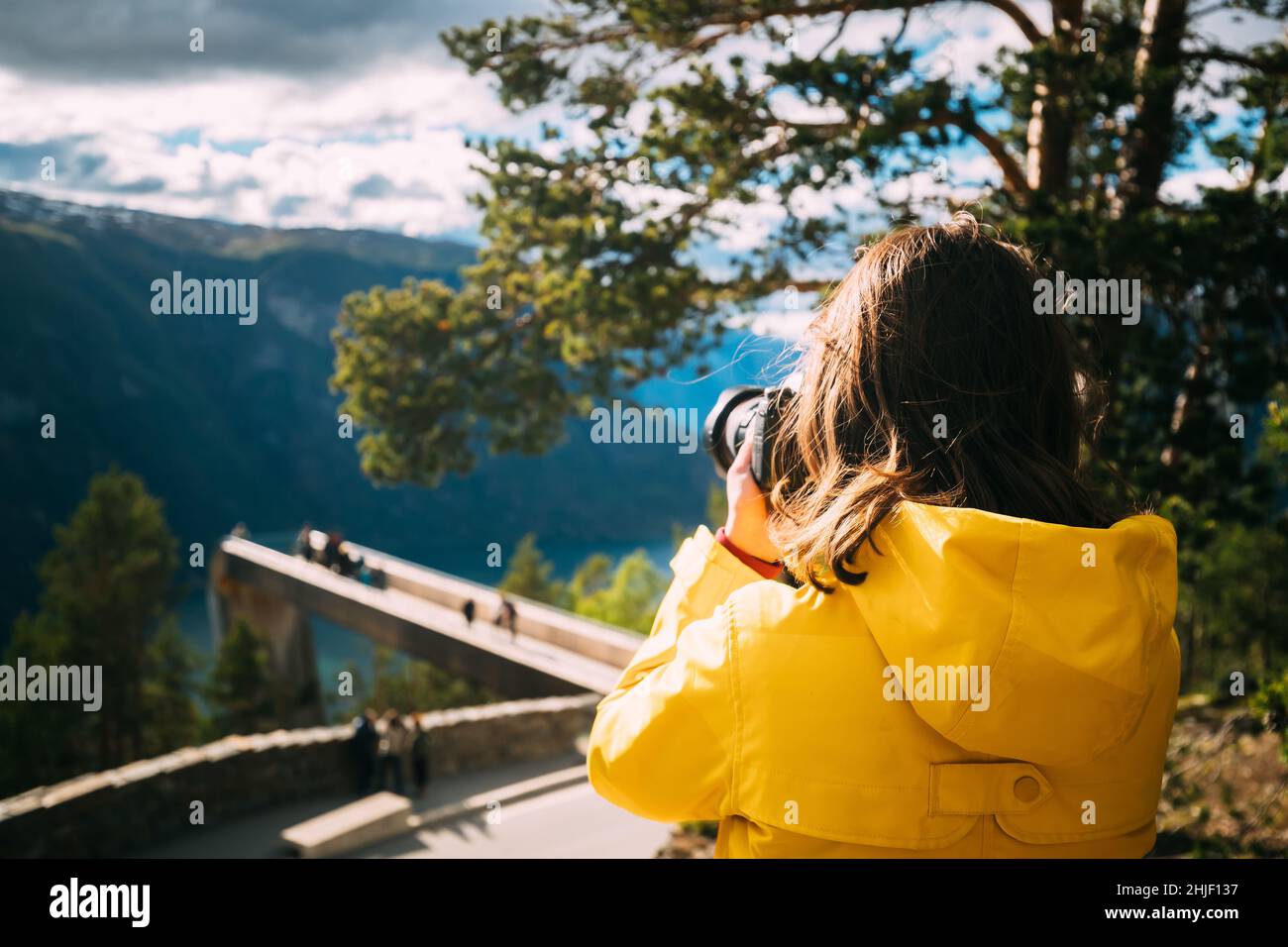 Norway. Young Adult Caucasian Woman Lady Tourist Traveler Photographer Taking Pictures Photos Near Stegastein Viewpoint In Sogn And Fjordane Fjord Stock Photo