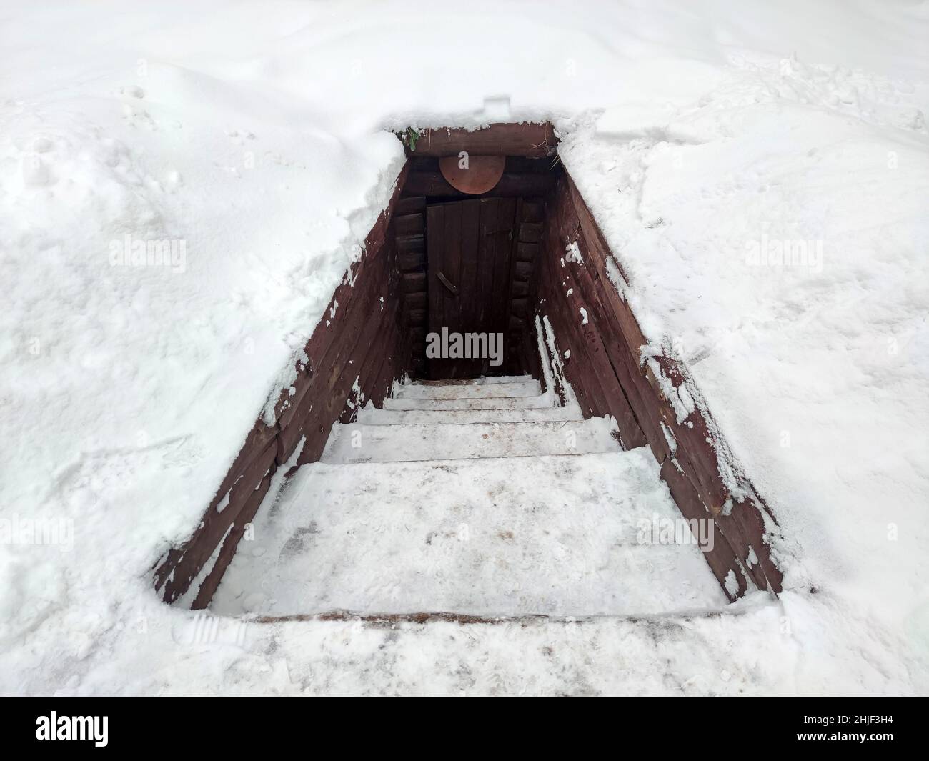 Partisan dugout in winter forest. Earth-house built by Soviet partisans in Ukrainian forest during Secont World War. Stock Photo