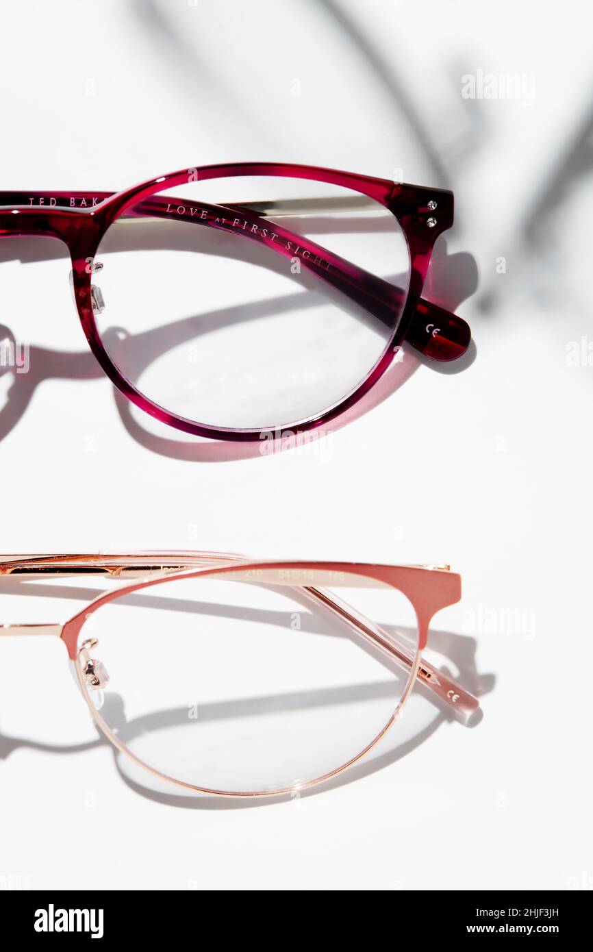 A photo showing part of two eyeglasses of different frame colors