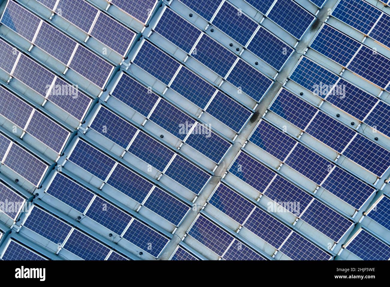 Aerial view of blue photovoltaic solar panels mounted on industrial ...