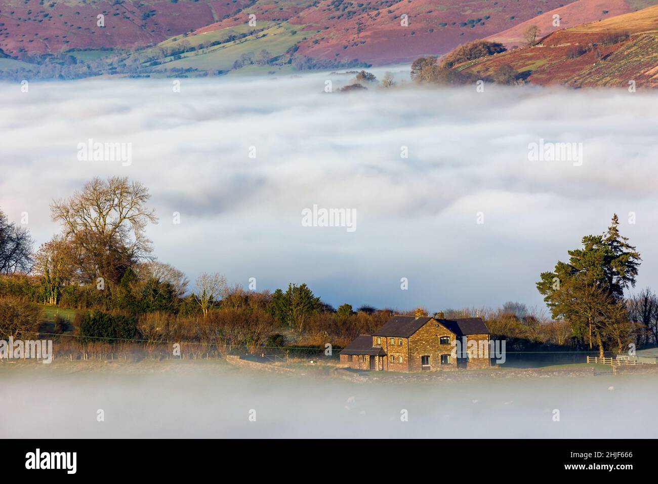 Farmland above low lying fog and a cloud inversion in the Brecon Beacons, Wales, UK Stock Photo