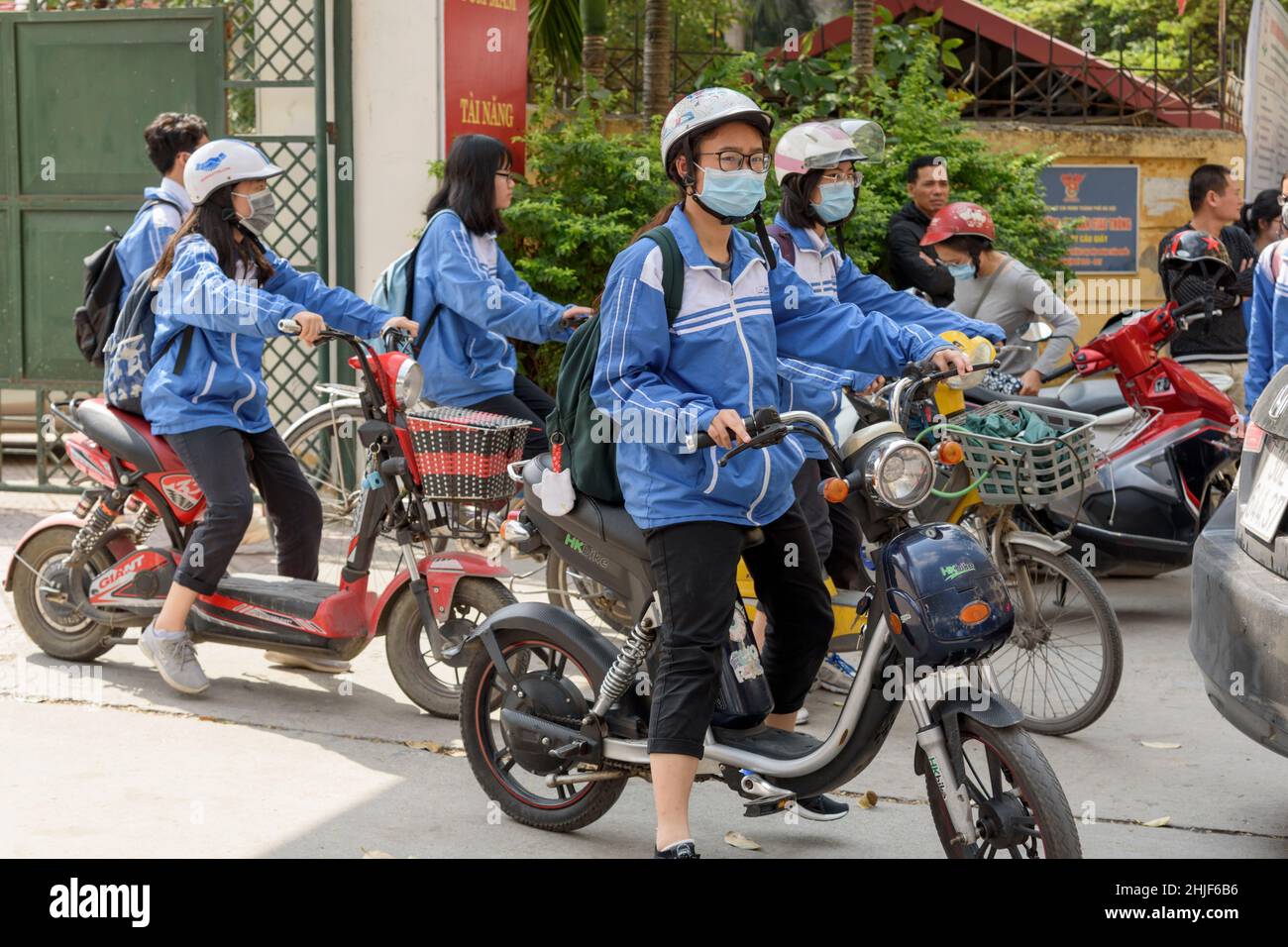 Vietnamese schoolchildren, wearing their blue uniforms, leave school at lunch time in Hanoi, Vietnam, Southeast Asia Stock Photo