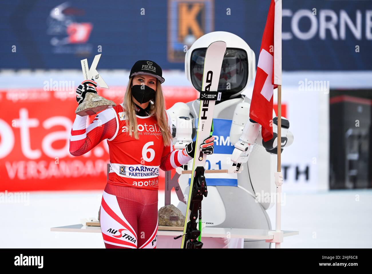 Garmisch Partenkirchen, Germany. 29th Jan, 2022. Alpine skiing: World Cup,  downhill, women: third-placed Cornelia Hütter from Austria (l) receives her  trophy from robot GARMI during the award ceremony. GARMI was developed by