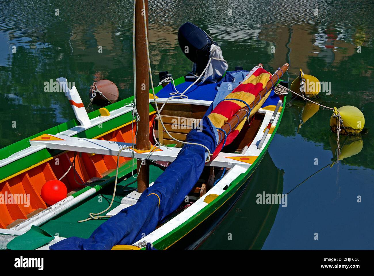 Fishing boat in bright colors anchored in a harbor in Italy. Stock Photo