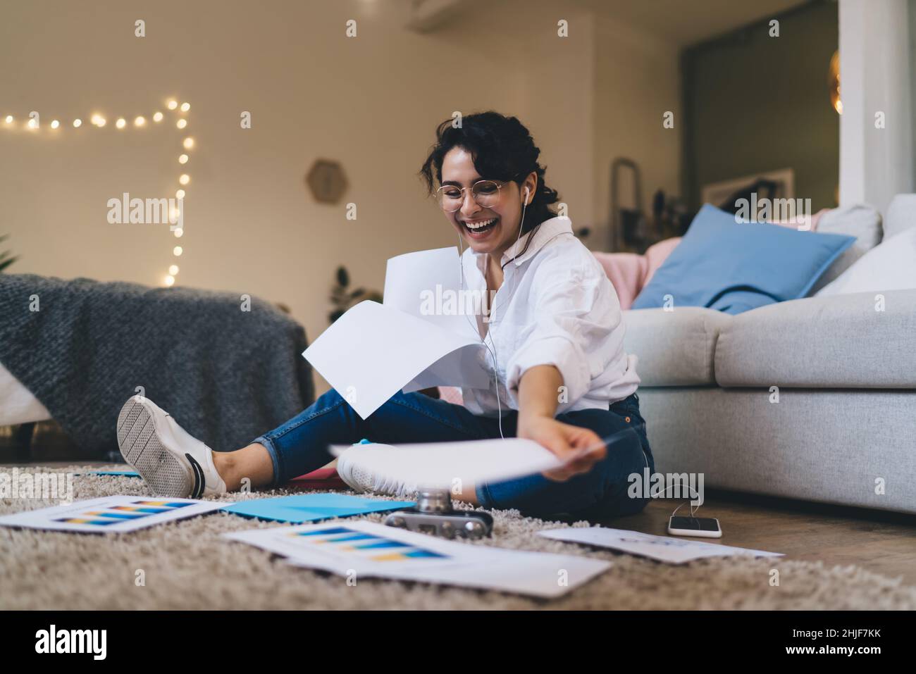 Laughing woman sitting on floor and doing paperwork Stock Photo