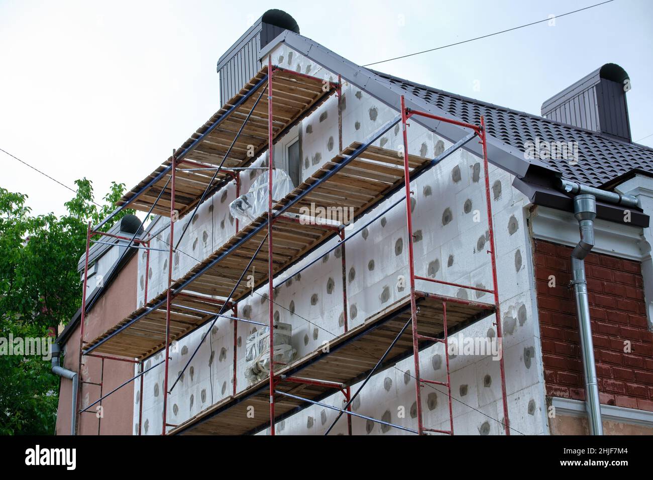 View of Building facade under renovation works with construction scaffolding ...