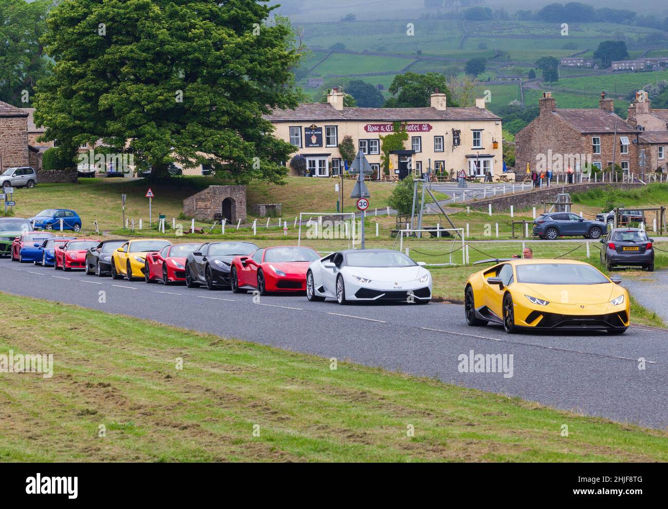 A Ferrari car club lined up in Bainbridge, Wensleydale for a drive around the Yorkshire Dales Stock Photo