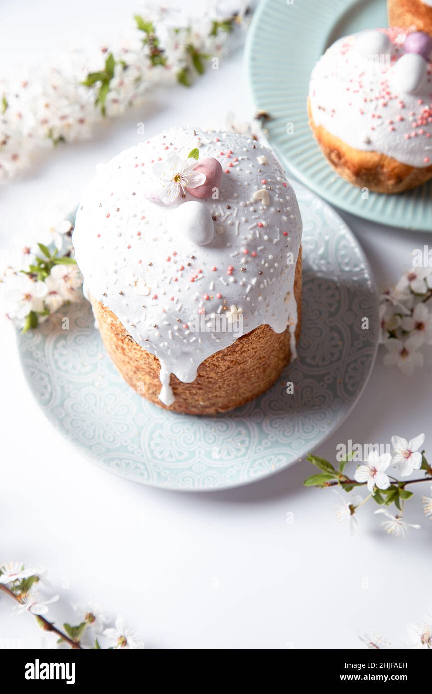 Easter cake with glace icing and decoration. Postcard with Easter bread. Christian traditions. Copy space. White background Stock Photo