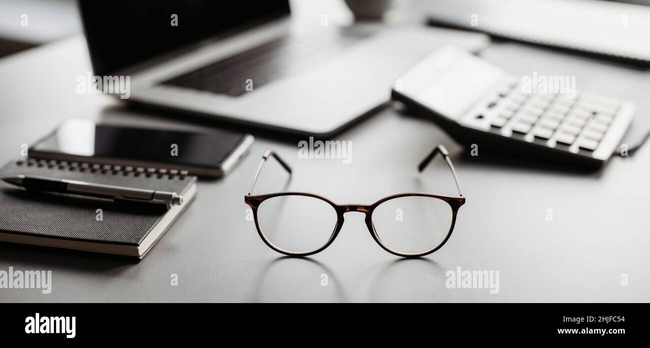 Place of work at home office, calculator, laptop computer on desk. Financial planning, advisor, accountant, banking Stock Photo