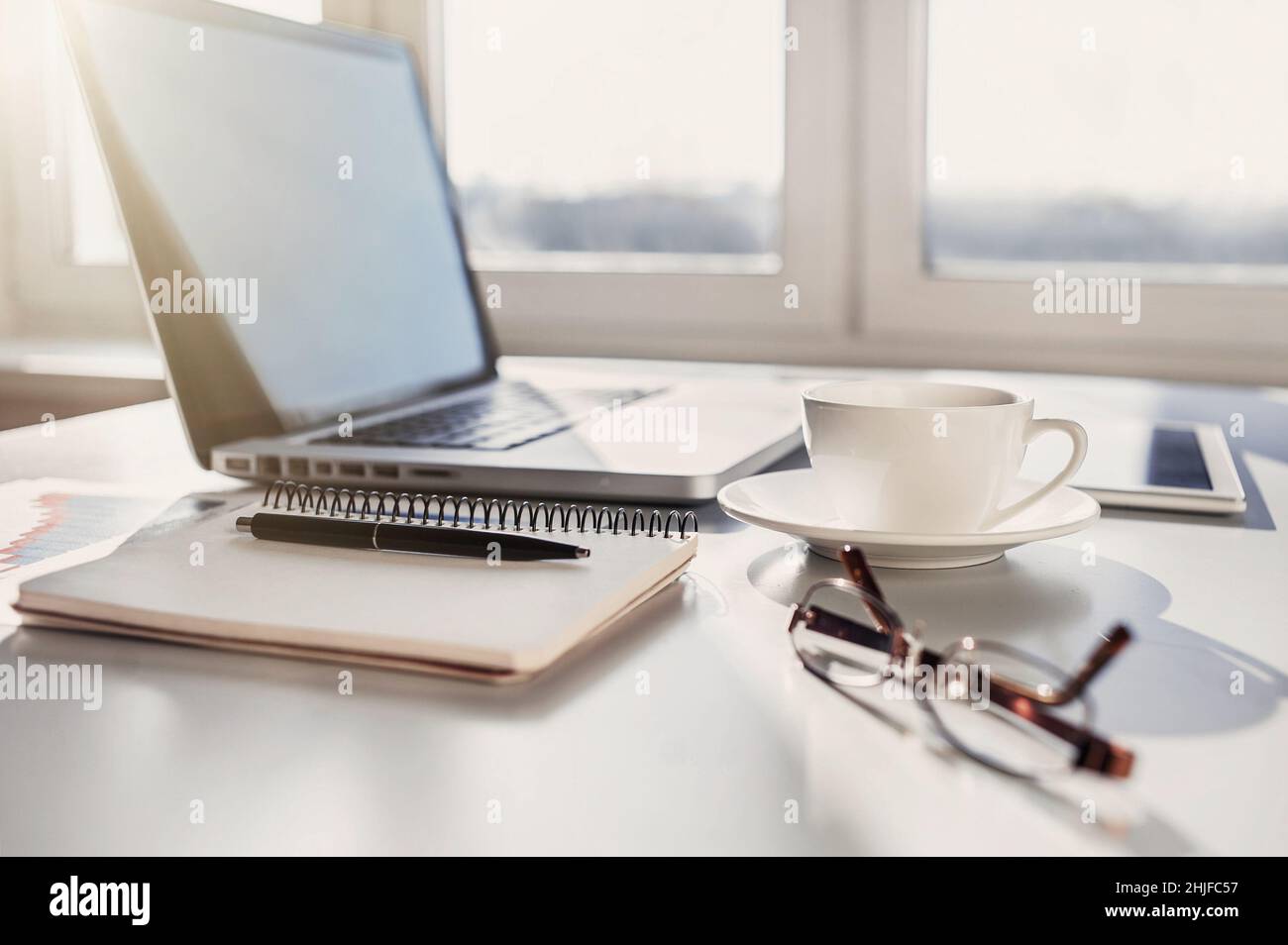 Place of work at home office, coffee, laptop computer on desk. Financial planning, advisor, accountant, banking Stock Photo