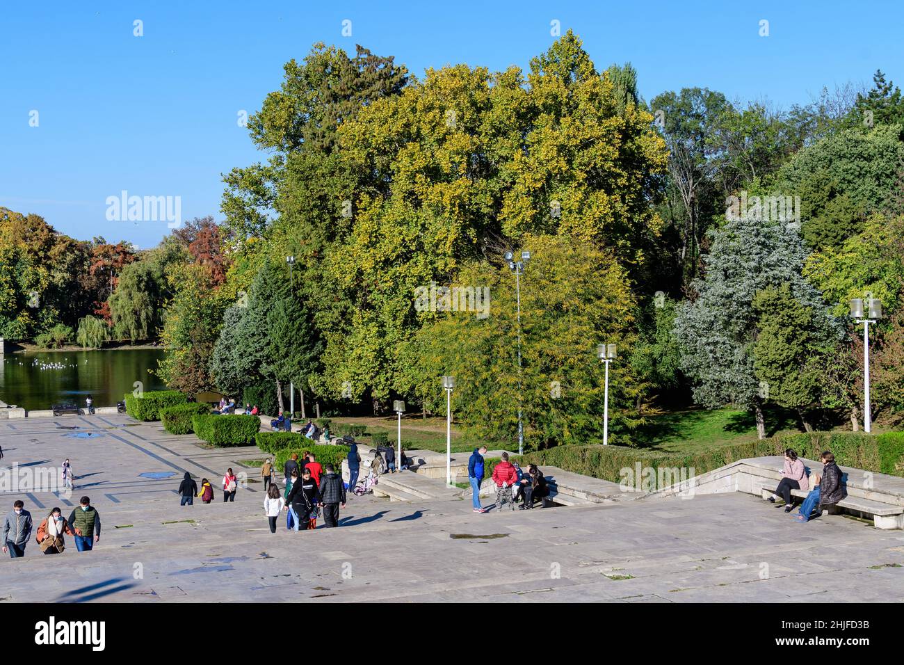 Bucharest, Romania, 1 November 2020: Landscape with the main alley and stairs surrounded by green, yellow, orange and brown leaves on large old trees Stock Photo
