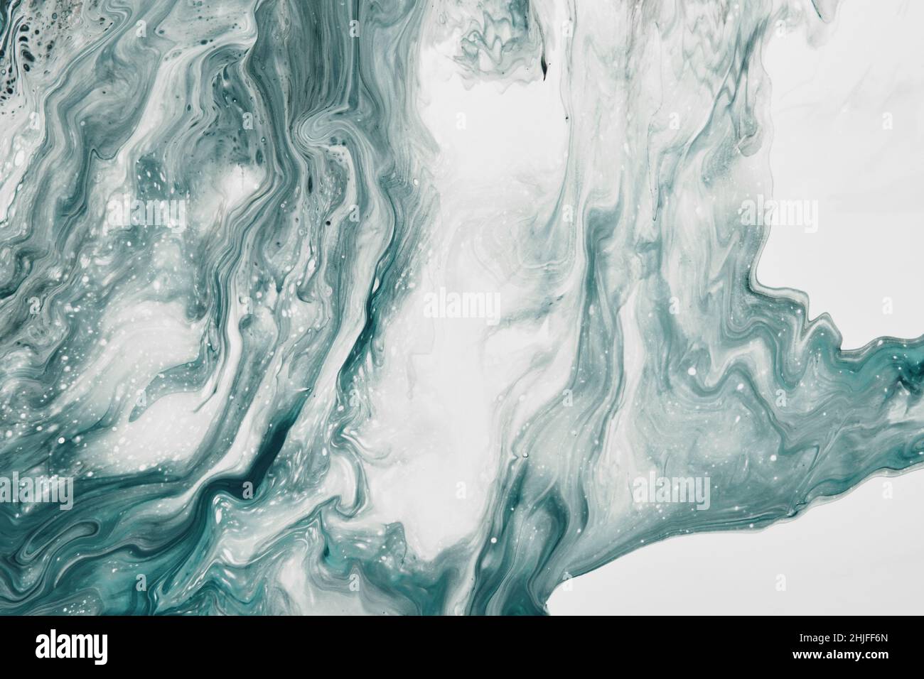 Fluid Art. Liquid transparent white and green abstract paint drips and wave. Marble effect background or texture. Stock Photo