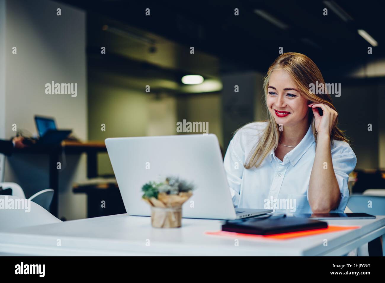 Smiling remote worker sitting at cafe and working on laptop Stock Photo