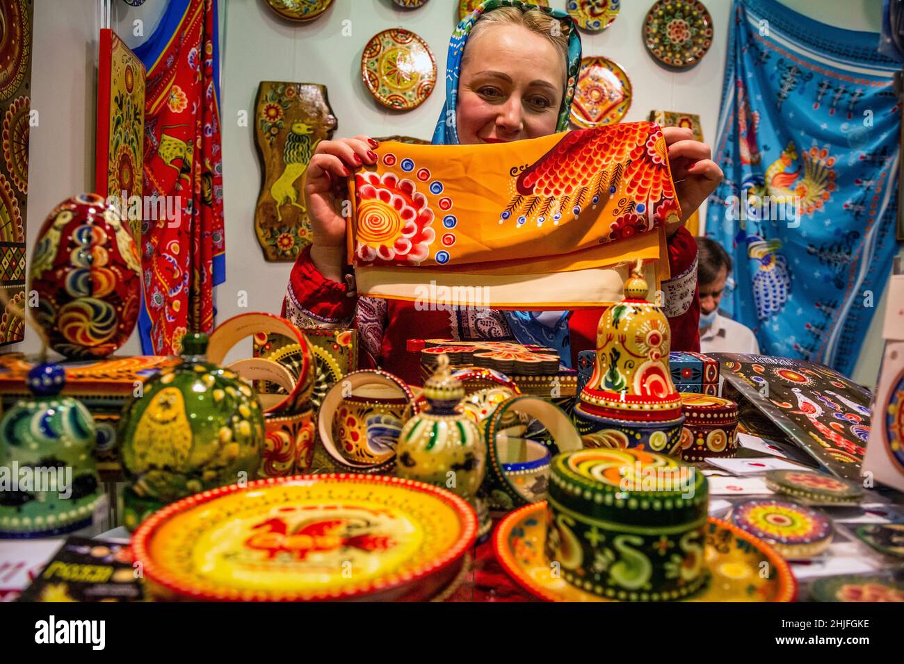 Moscow, Russia. 18th December, 2021 A saleswoman presents traditional Vyatka paintings at an souvenir shop at the exhibition-fair of folk art crafts of Russia 'Ladya' at Moscow's Expocentre, Russia Stock Photo