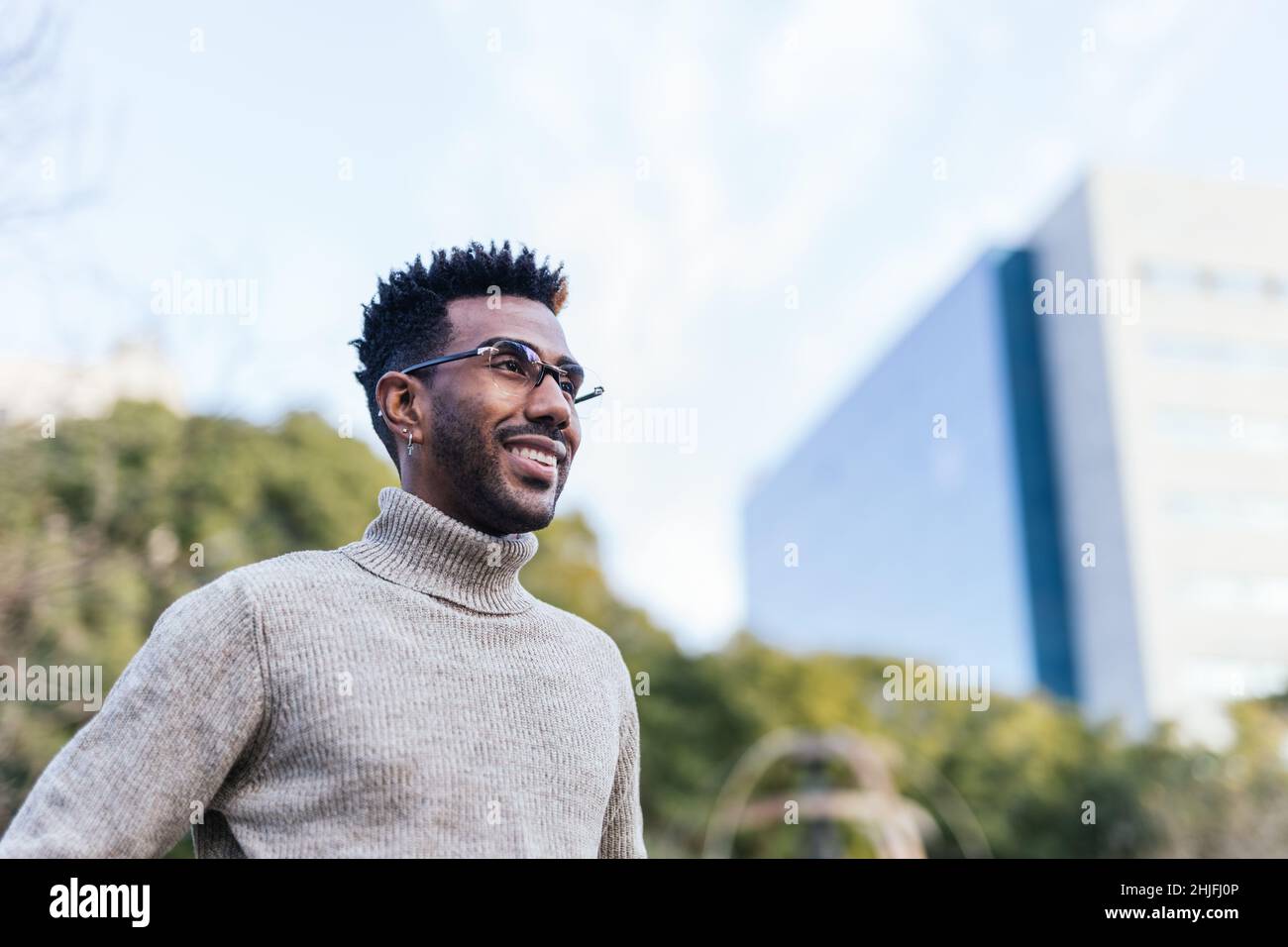 Smiling african american man in turtleneck vest looking at horizon Stock Photo