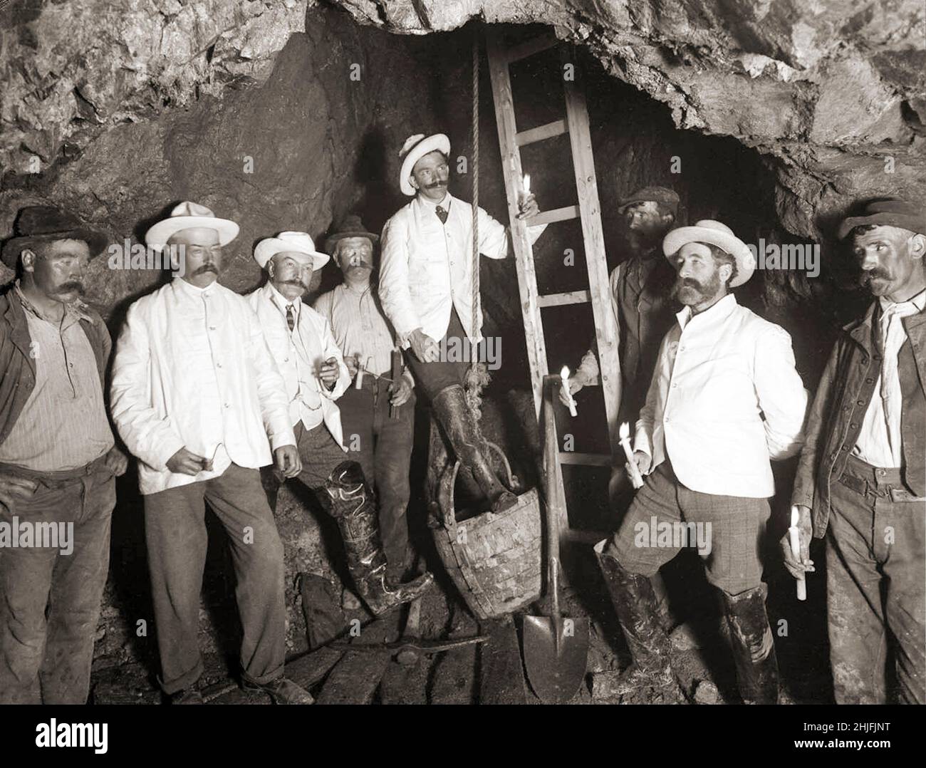 A vintage photograph of miners and managers (the clean ones) in the copper mine at Tankardstown shot on 1906. The The Mining Company of Ireland was established in Dublin in 1824 and quickly took leases on mineral areas all over the country. Knockmahon proved to be the most profitable of all their operations, but by 1840 it was at its peak. In their search for other lodes in the neighbourhood they discovered Tankardstown just as Knockmahon was threatening to flood. Stock Photo