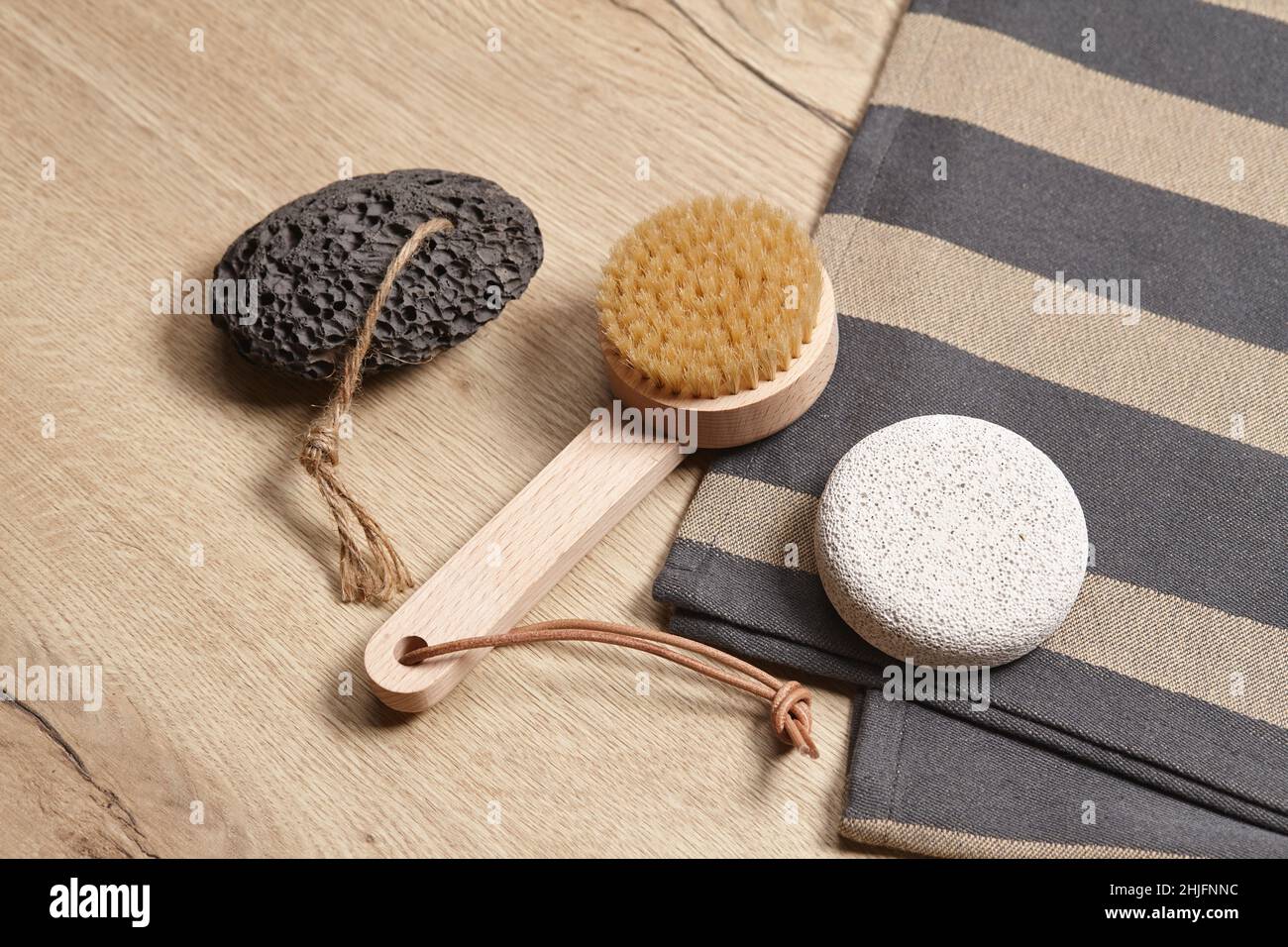 Wooden brush and pumice stones on wooden background Stock Photo