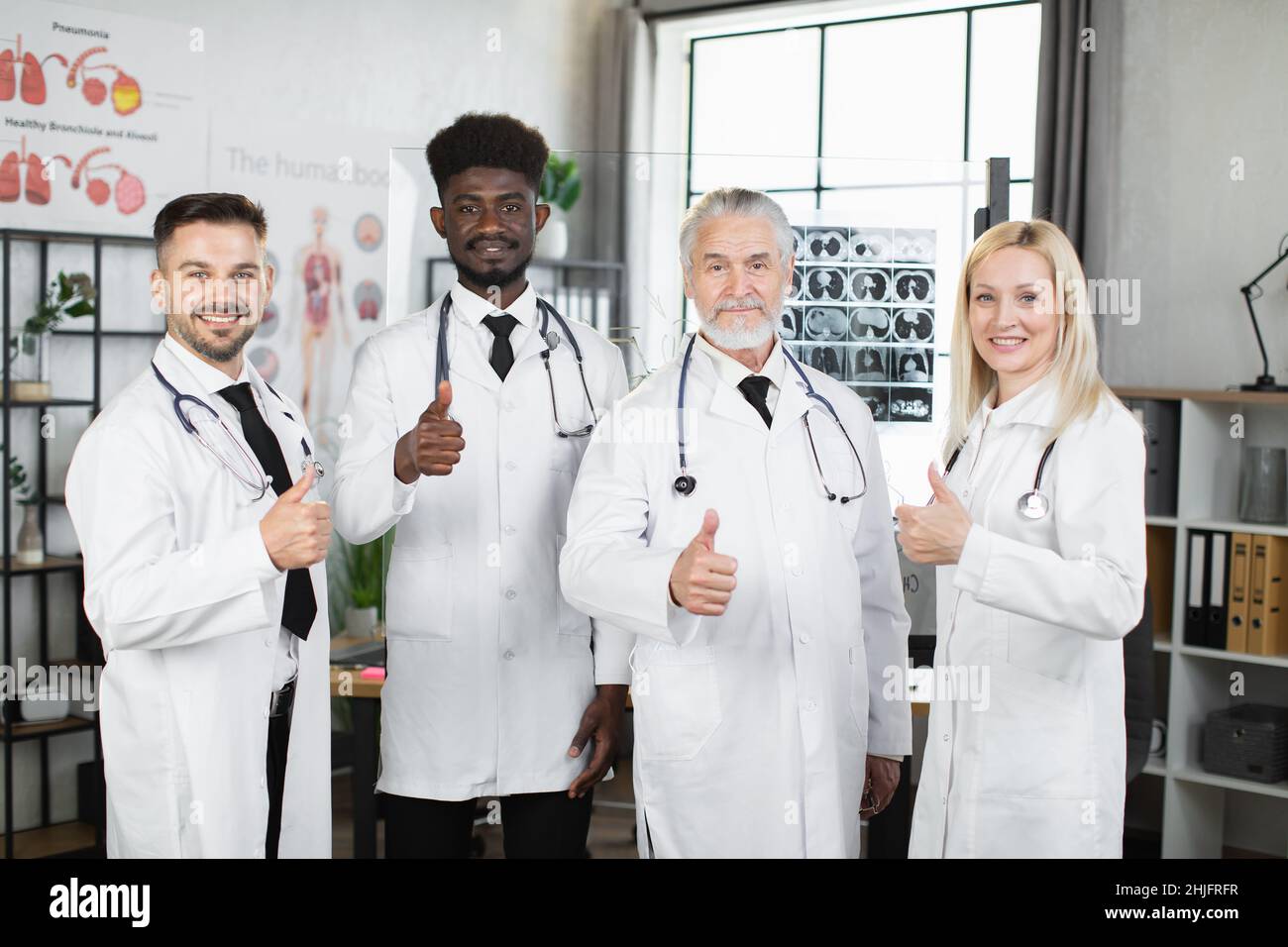 Group of multicultural doctors showing thumbs up and smiling on camera ...