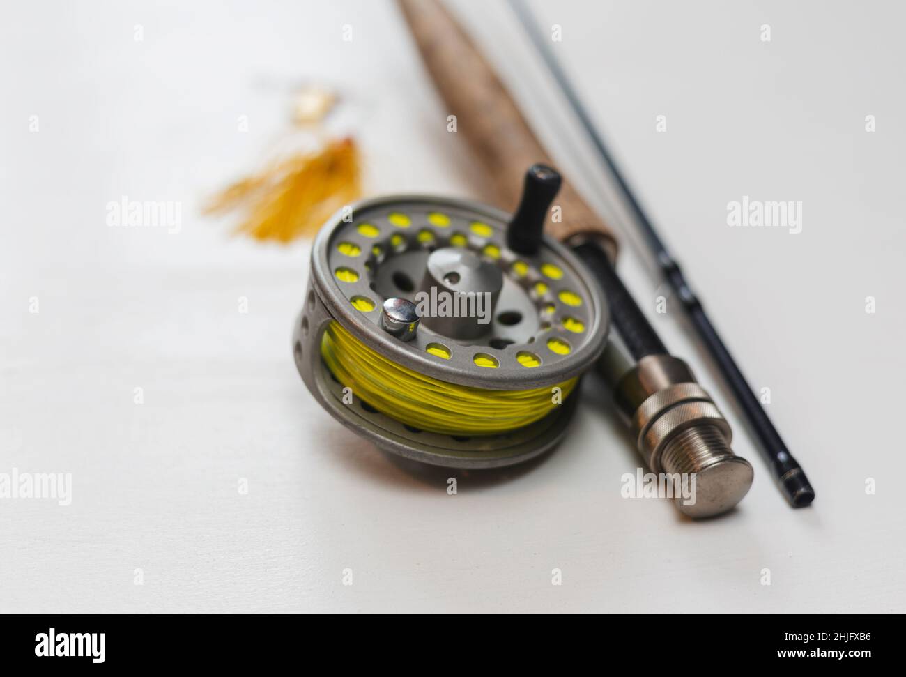 Fly fishing rod and reel with a yellow line on a white background Stock