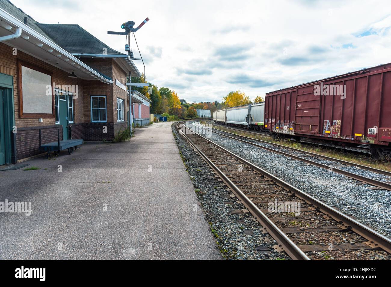 Cargo railcars in a deserted station on a cloudy autumn day Stock Photo