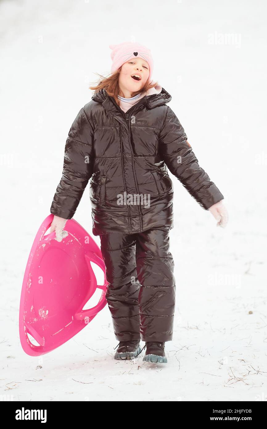 Happy little girl sliding down the hill on saucer sled. Girl enjoying ...