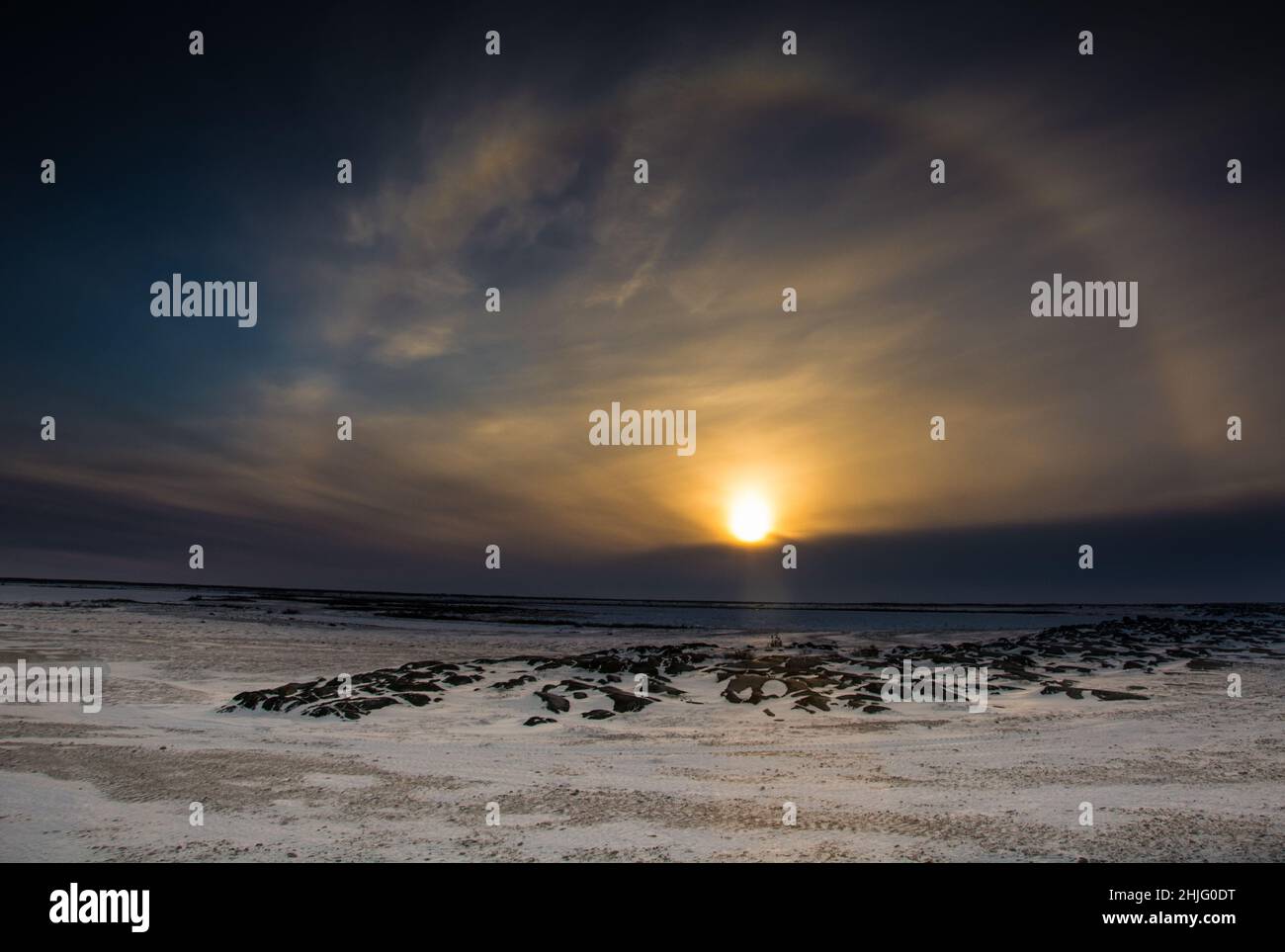 A sun dog around at sunset over the frozen, snow covered groud outside of Churchill, Manitoba Stock Photo