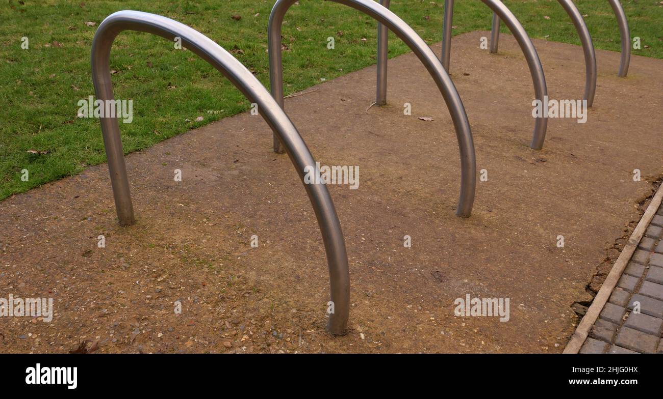 Metal cycle rack or stands on hardstanding beside grass lawn Stock Photo