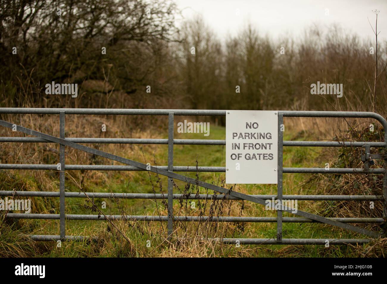 white sign with no parking in front of gates on a metal gate Stock ...