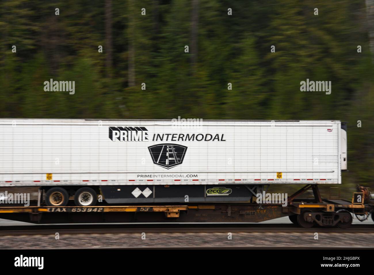 A Prime Intermodal shipping container on the BNSF railway along their Northern Transcon route running from Seattle to Chicago. Near Troy, Montana. Stock Photo