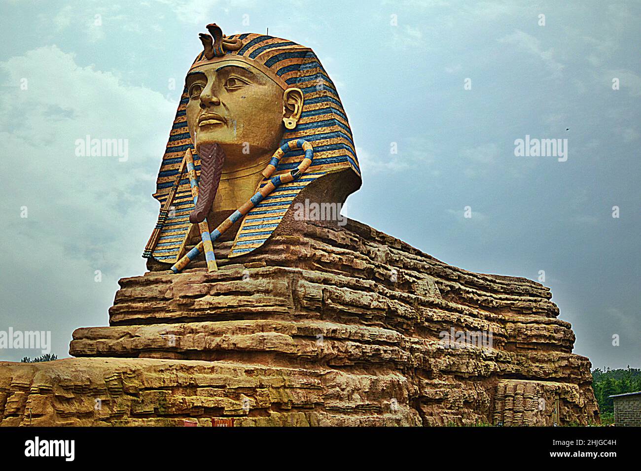 Close-up shot of an Egyptian pharaoh statue under the blue cloudy sky ...