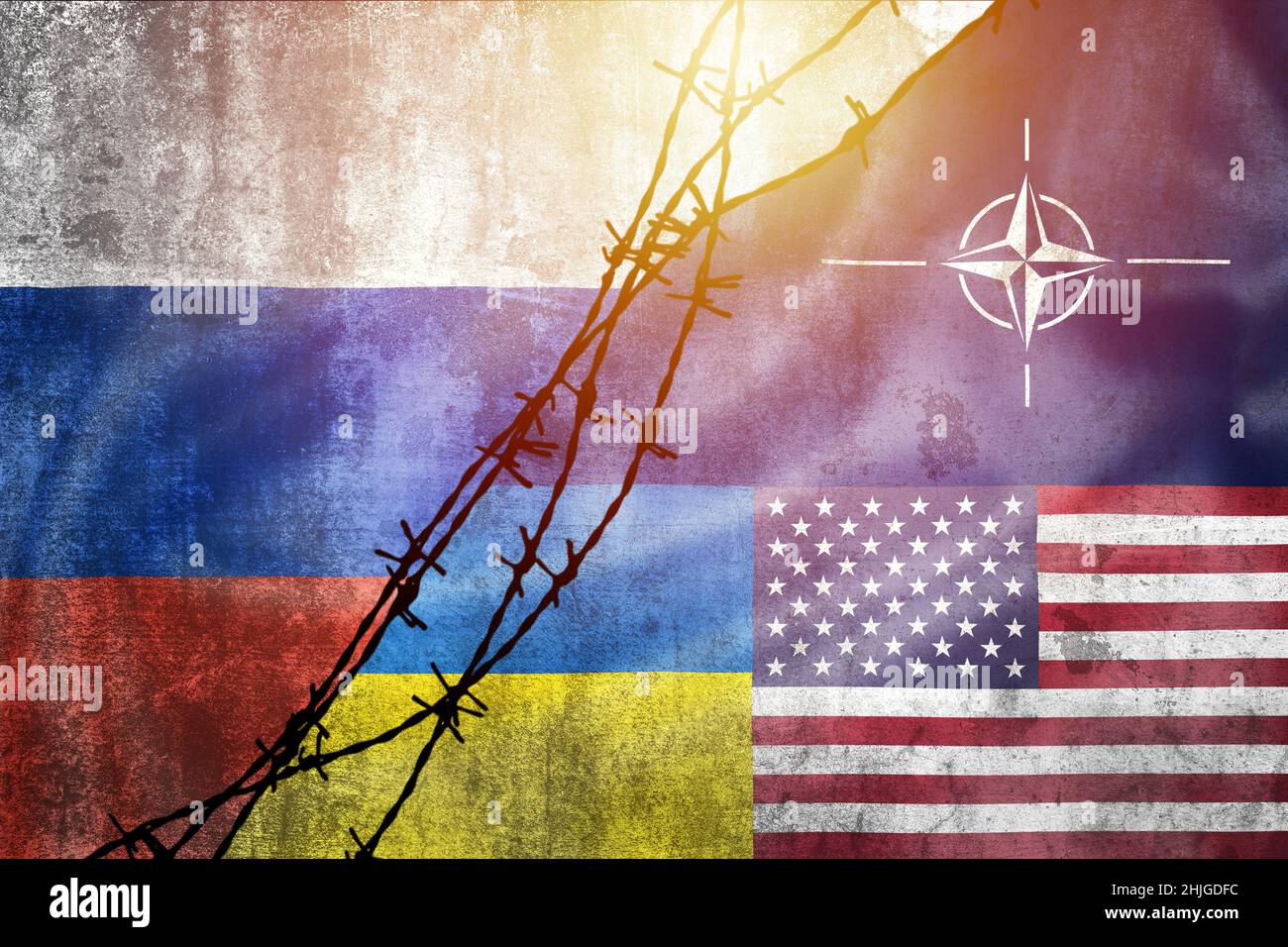 Grunge flags of Russian Federation, NATO, USA and Ukraine divided by barb wire sun haze illustration, concept of tense relations between west and Russ Stock Photo